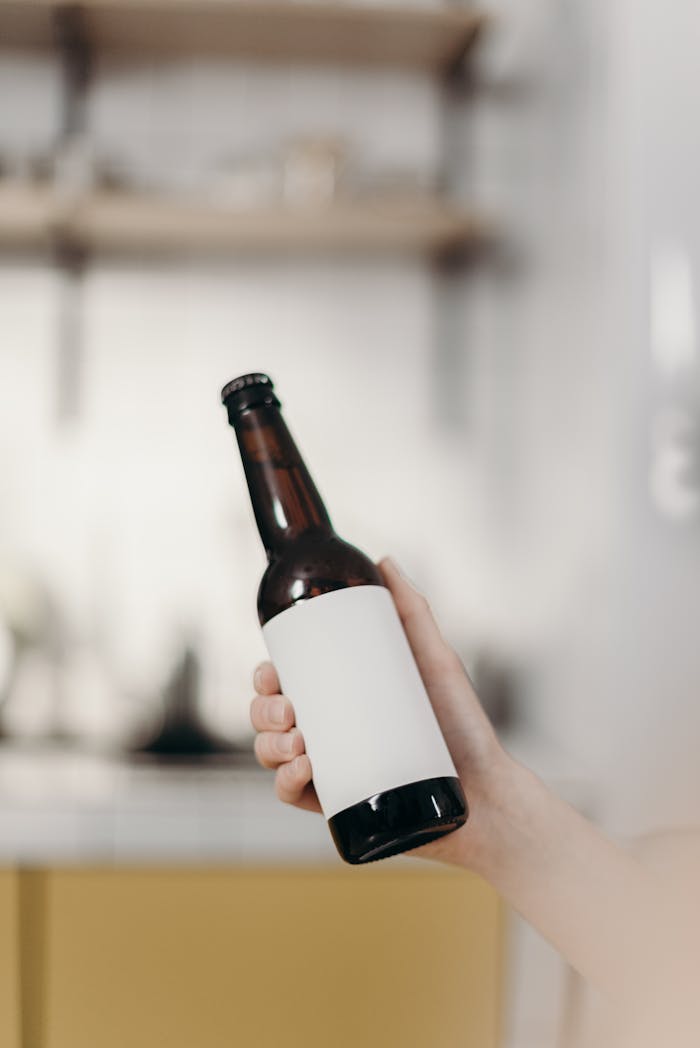 Person Holding White Labeled Bottle